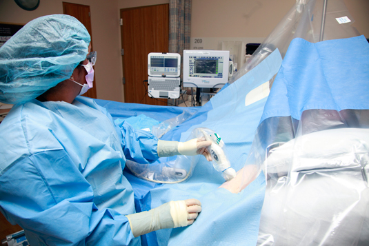 Figure 1: A nurse on the PICC team at Sutter Roseville Medical Center uses ultrasound, maximum barrier precautions, and a device bundle including a specific catheter stabilization device, IV connector, and other technology. This approach has eliminated central-line associated bloodstream infections for more than seven years. Courtesy of John Milne, Sutter Health